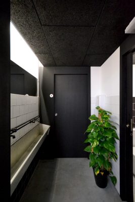 Acceso a los baños azulejo blanco y color negro
