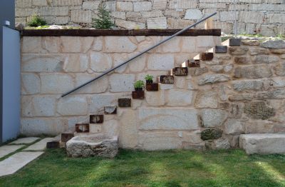 Escalera de traviesas de tren en muro de piedra