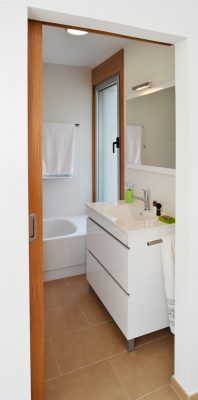 Baño con acabados blancos para vivienda en Vilaboa